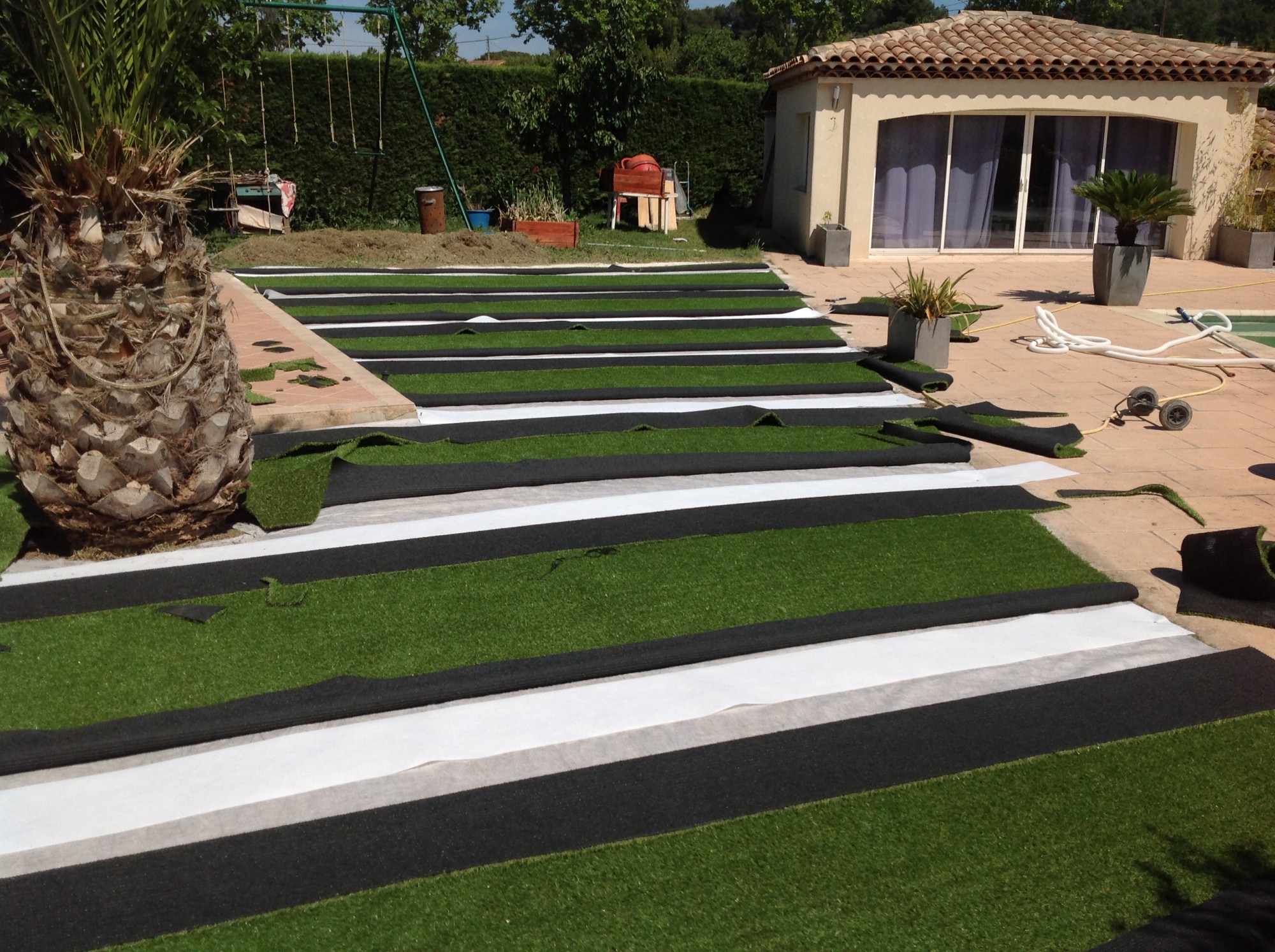 Mise en place des bandes de pontage pour la pose d'un gazon synthétique à Plan de campagne